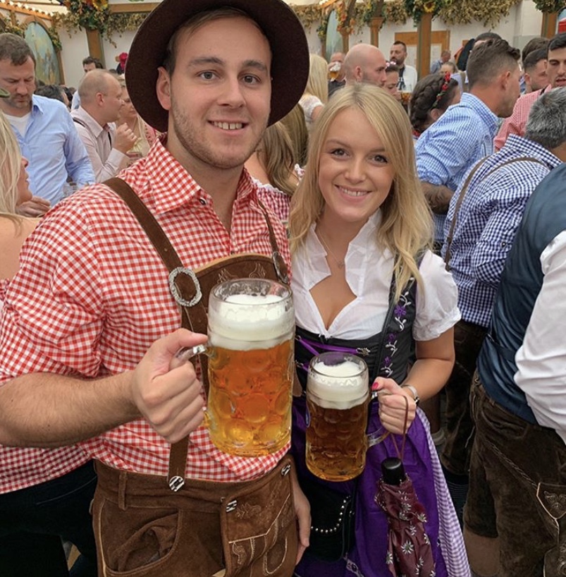 A couple in Bavarian outfits with beer