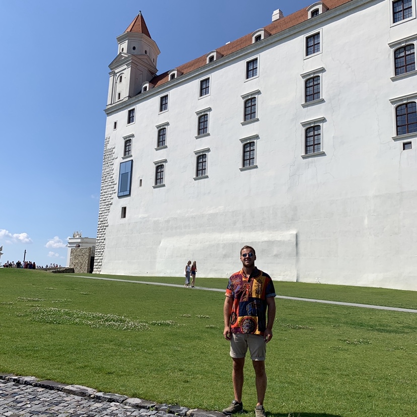 A man stood in front of the Bratislava castle. Advised to visit from the Bratislava travel guide.