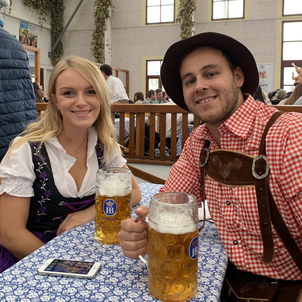 A couple in an Oktoberfest tent, part of what to do at Oktoberfest.