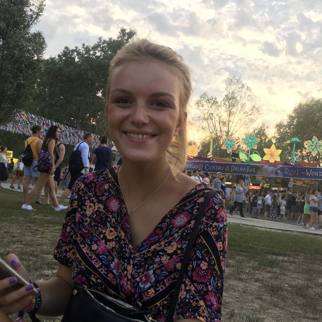 A woman sat smiling at Sziget festival