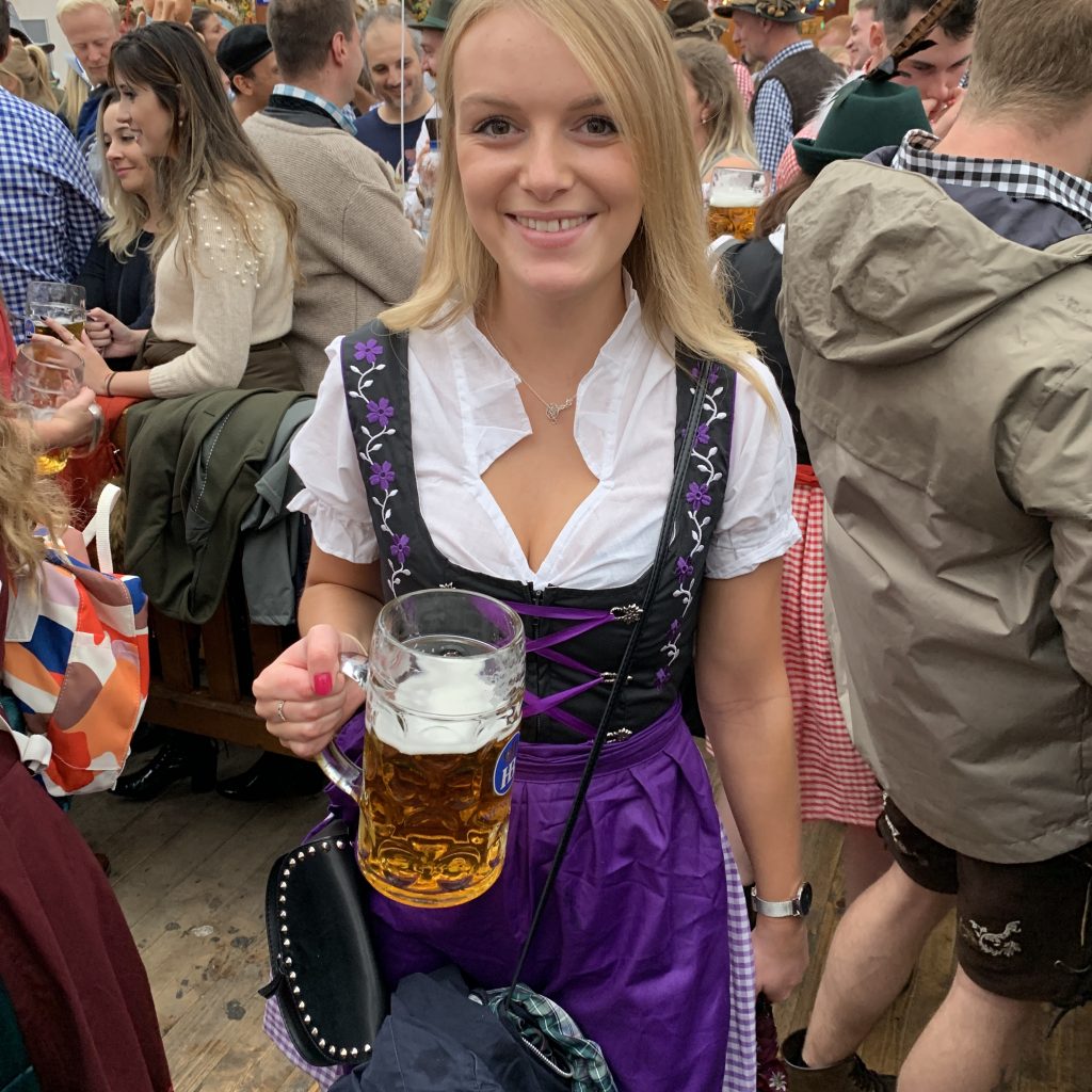 A woman in a dirndl and with a beer.