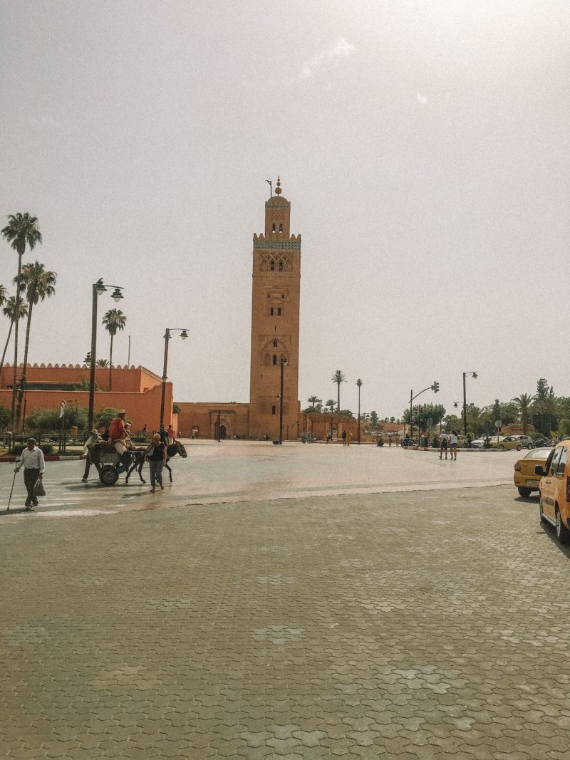 A tall tower near palm trees in Marrakech. Morocco Travel guide
