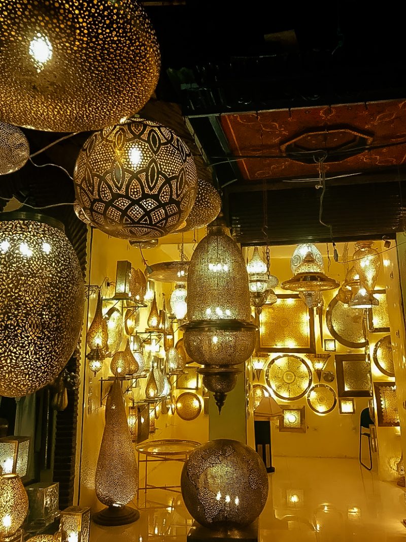 Golden ornaments hang from the ceiling in a Marrakech market.