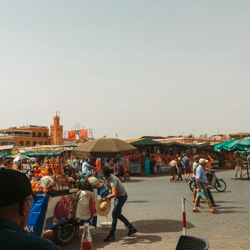 People and market stalls in an open Marrakech market. Part of the things to do in Morocco