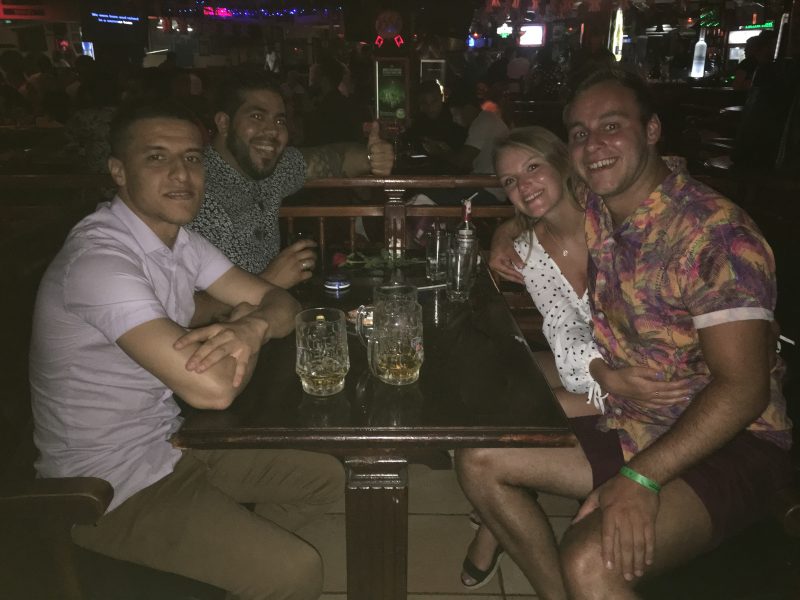 A group of people enjoying themselves with drinks in a bar