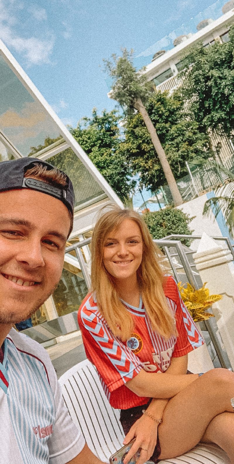 A couple taking a selfie at a hotel with trees in the background. Where to stay in Tenerife.