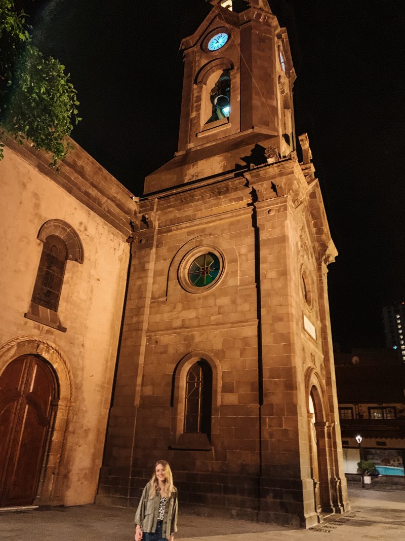A woman stood in front of a church at night. Where to stay in Tenerife