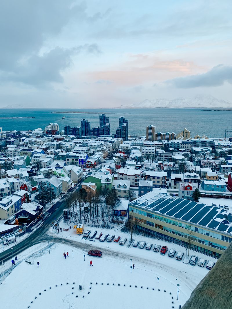 Aerial view of Reykjavik,Iceland in snow. Budget travel idea where you can see buildings and mountains from the Hallgrimskirkja church. Where to stay in Reykjavik