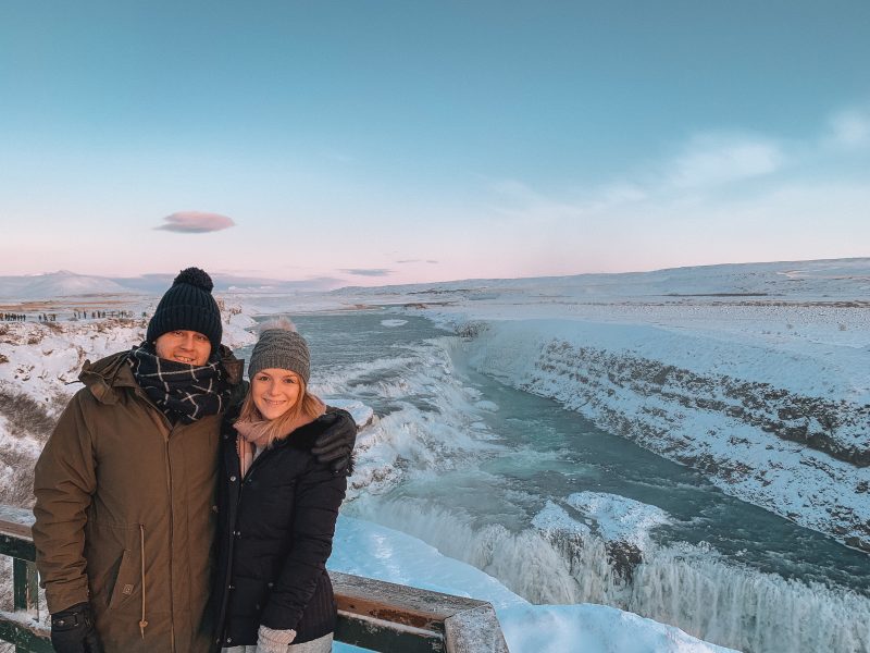 A couple stood in front of Gullfoss waterfall. Golden Circle tour as part of what to do in Iceland