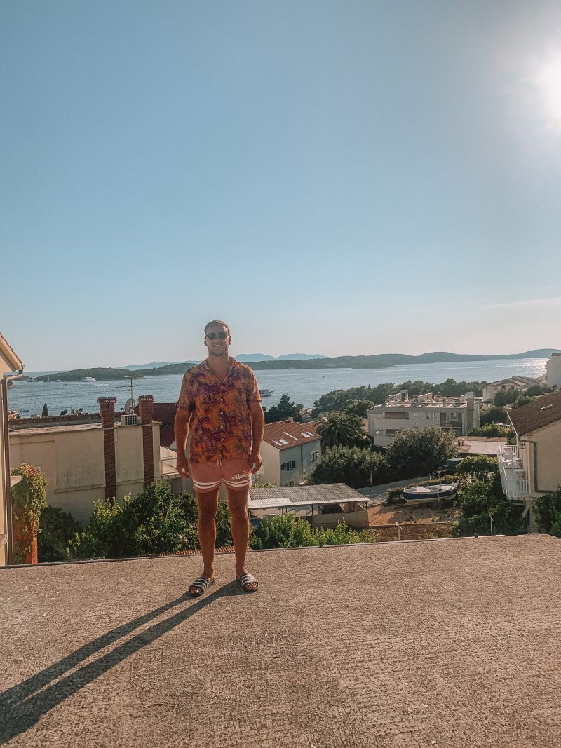 A man stood at a viewpoint with islands and the ocean in the background. Things to do in Hvar