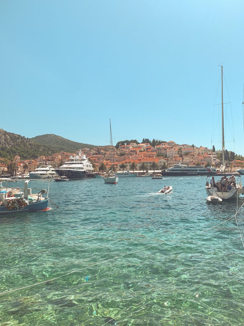 A harbour with boats and colourful buildings in the background. What to do in Hvar