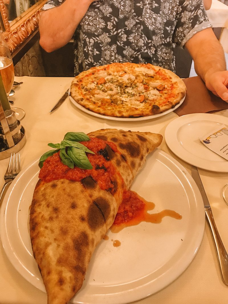 Tomato calzone pizza and a seafood pizza with beer. Venice in a day