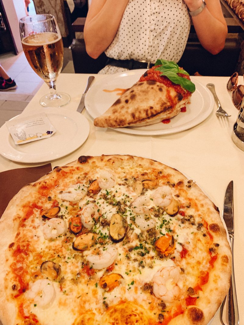 Seafood pizza and a Calzone pizza with wine. What to do in Venice