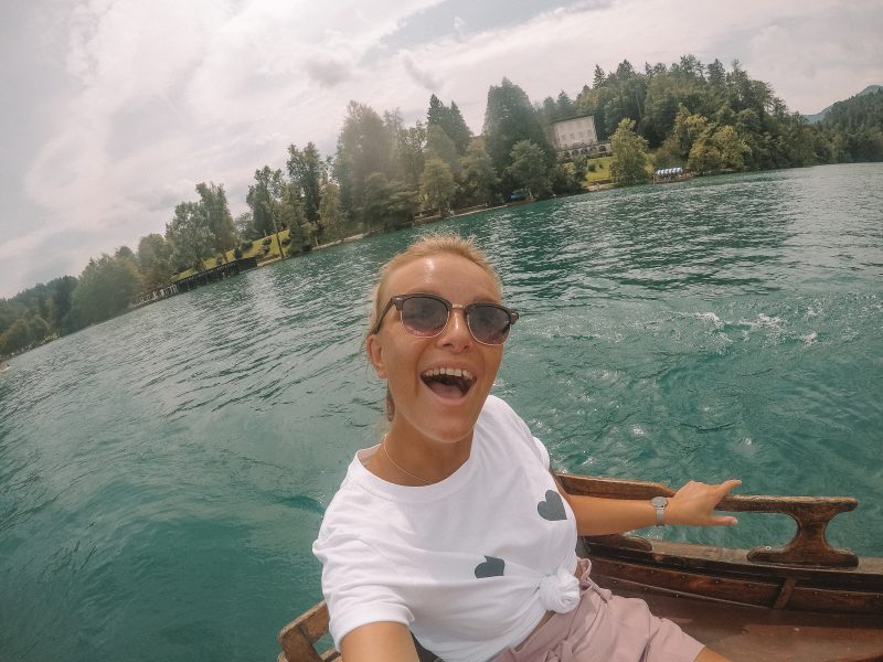 A woman taking a selfie in a rowing boat at lake bled