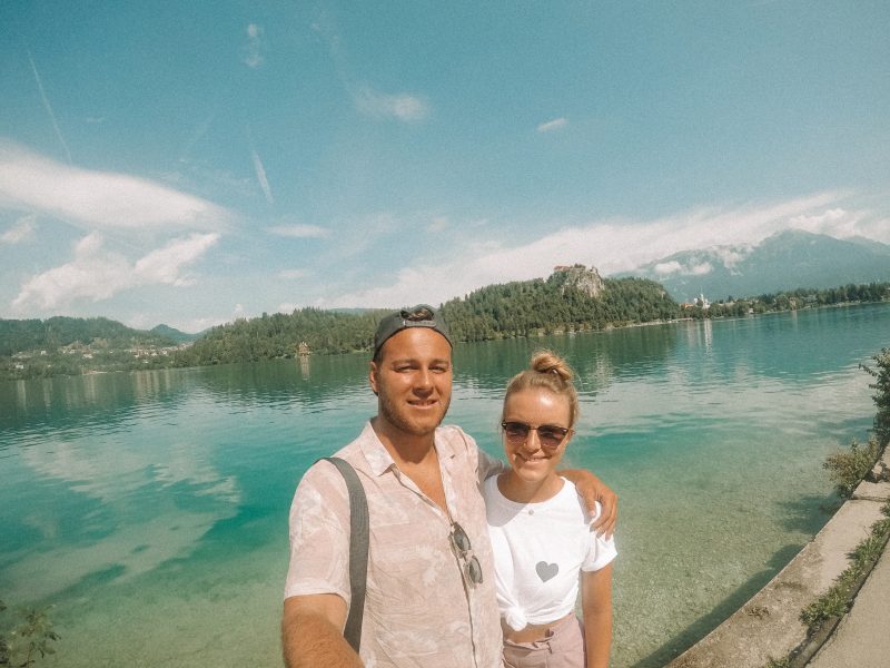 A couple taking a selfie with the castle and lake in Bled. What to do in Lake Bled