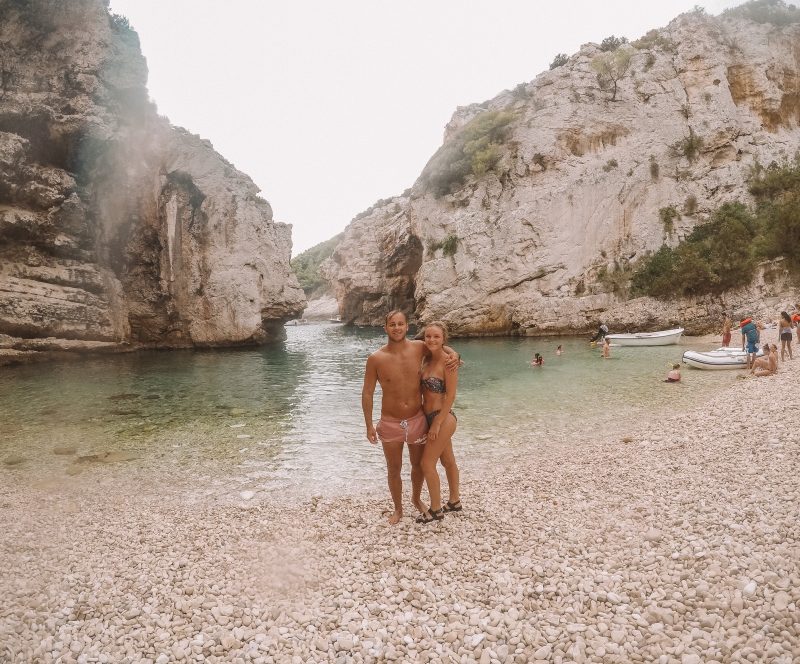 A couple on a pebble beach with a cave surrounding. Things to do in Hvar