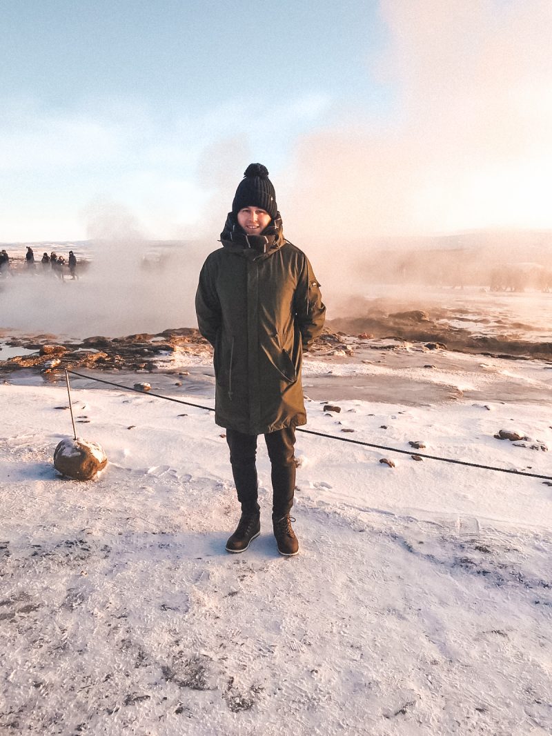 A man in front of a snowy Stokkur Geyser. Things to do in Iceland