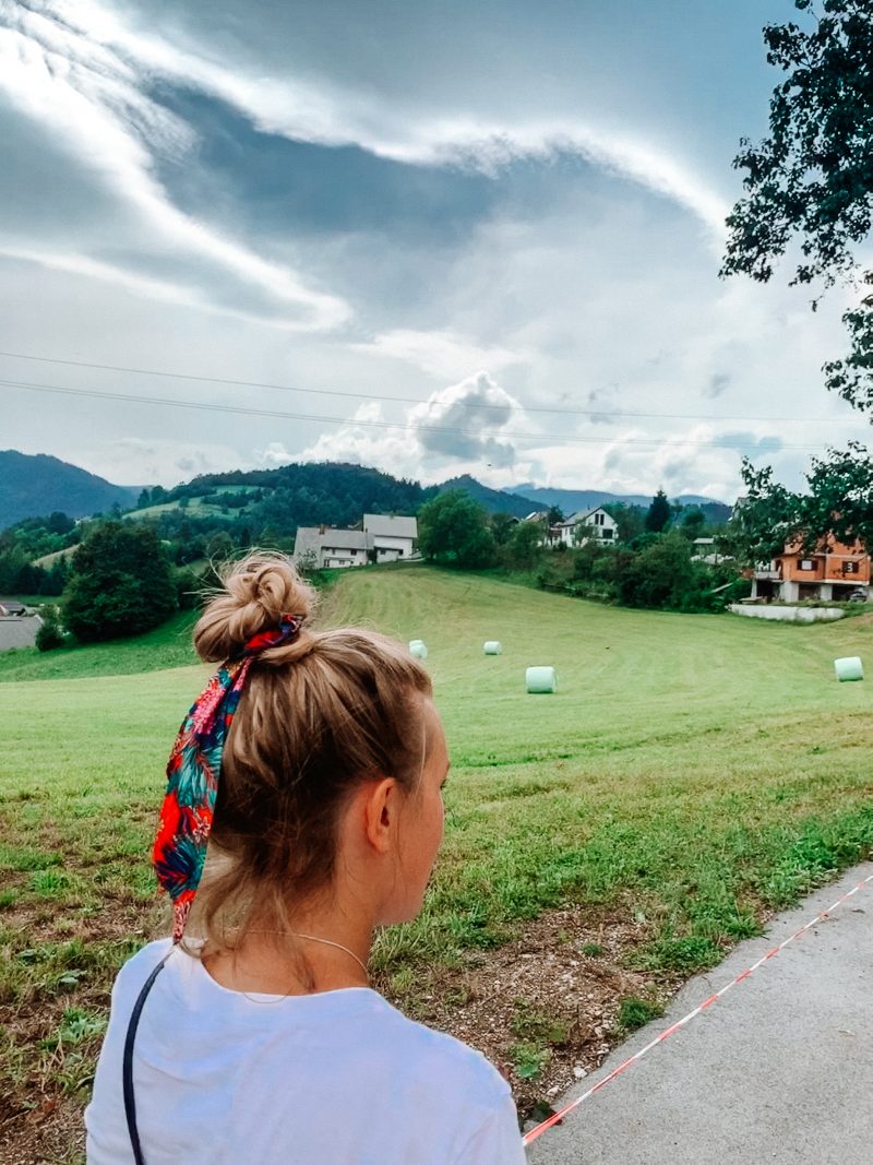 A woman walking near fields and farmland. Where to go in Bled