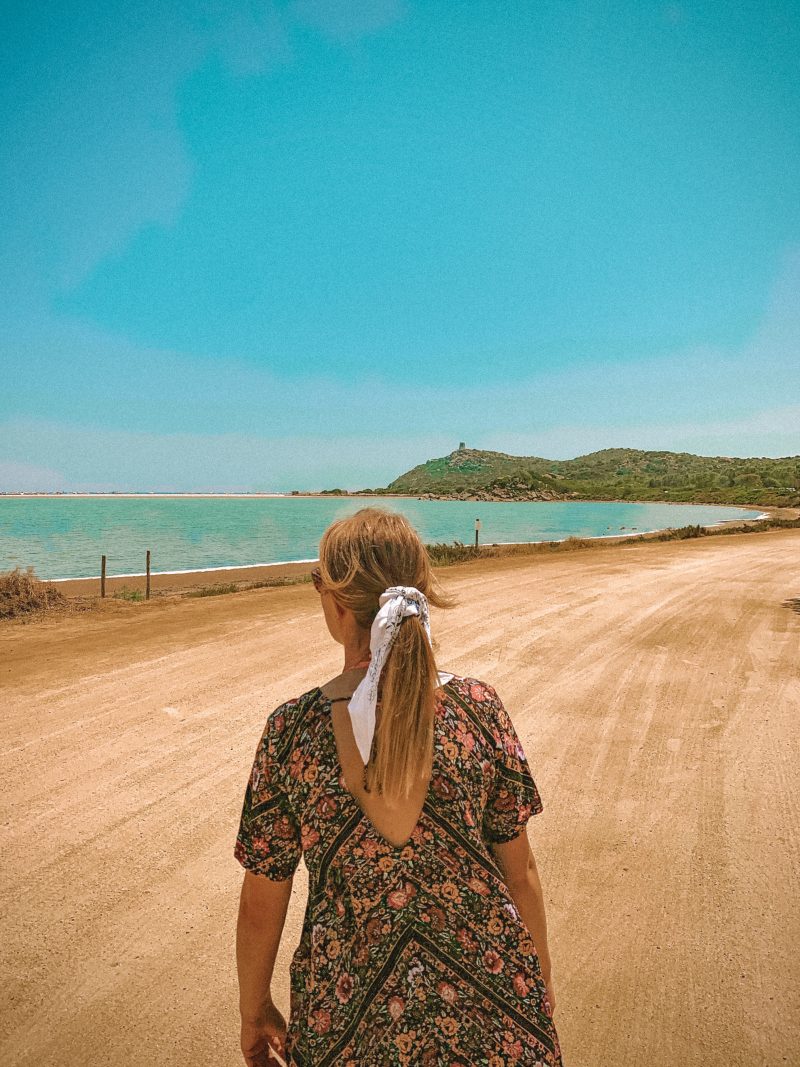 A woman walking to the beach and sea in Sardinia.