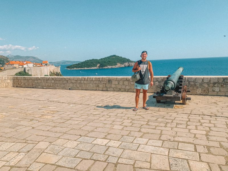A man stood next to a cannon on top of Lovrijenac fort