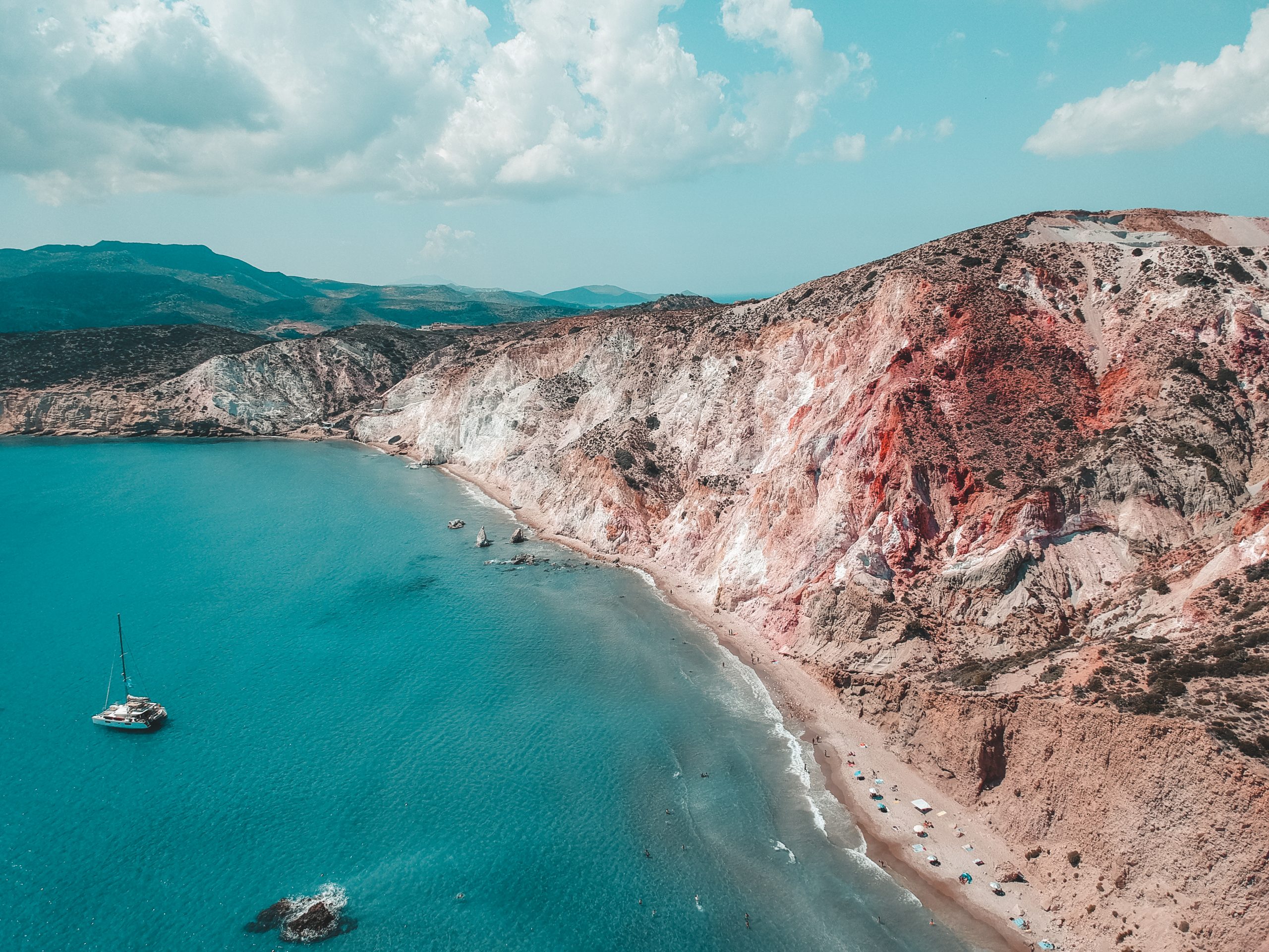 Firiplaka beach surrounded by red volcanic mountains. Things to do in Milos