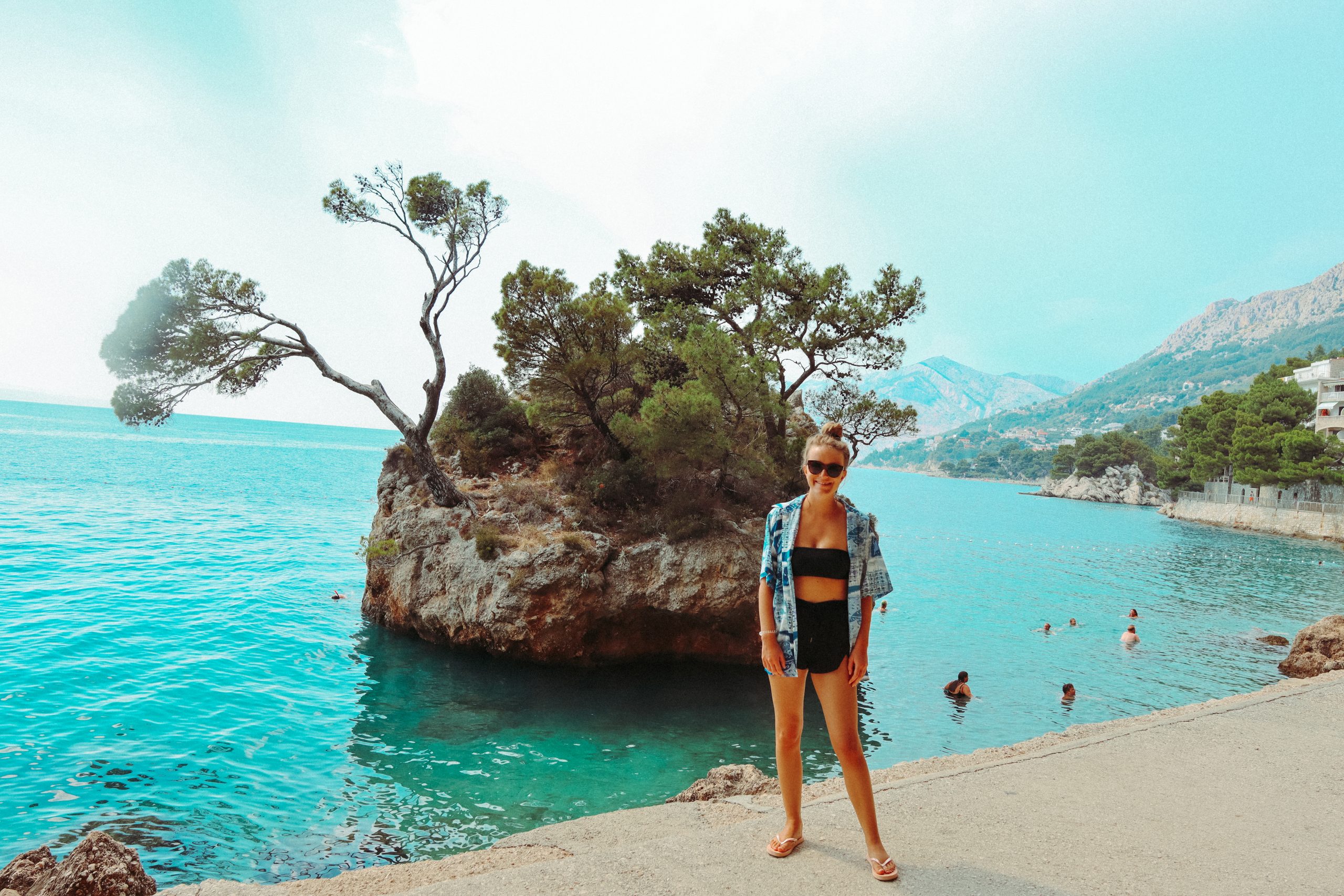 A woman stood in front of Kamen Brela. Your guide to the Croatian Riviera