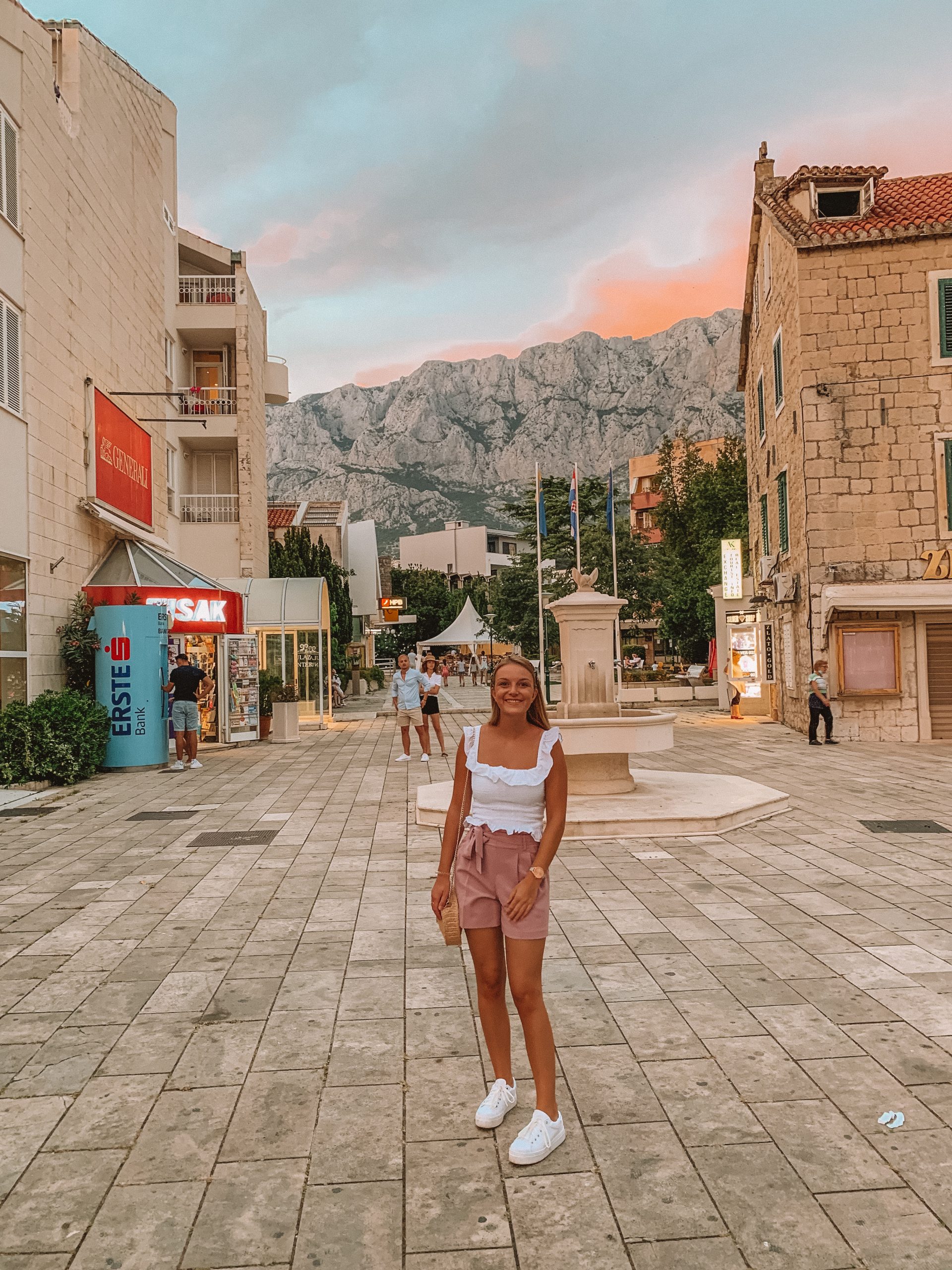 A woman in Makarska town with the mountain and sunset background