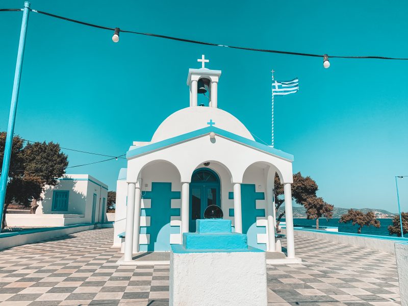 A blue and white painted church with a blue sky in the background. Things to see in Milos