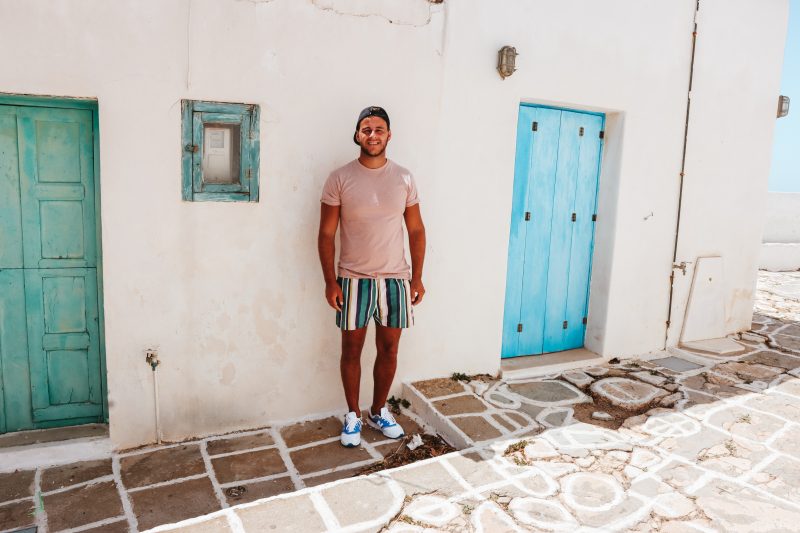 A man stood next to colourful doors at Folegandros Castro