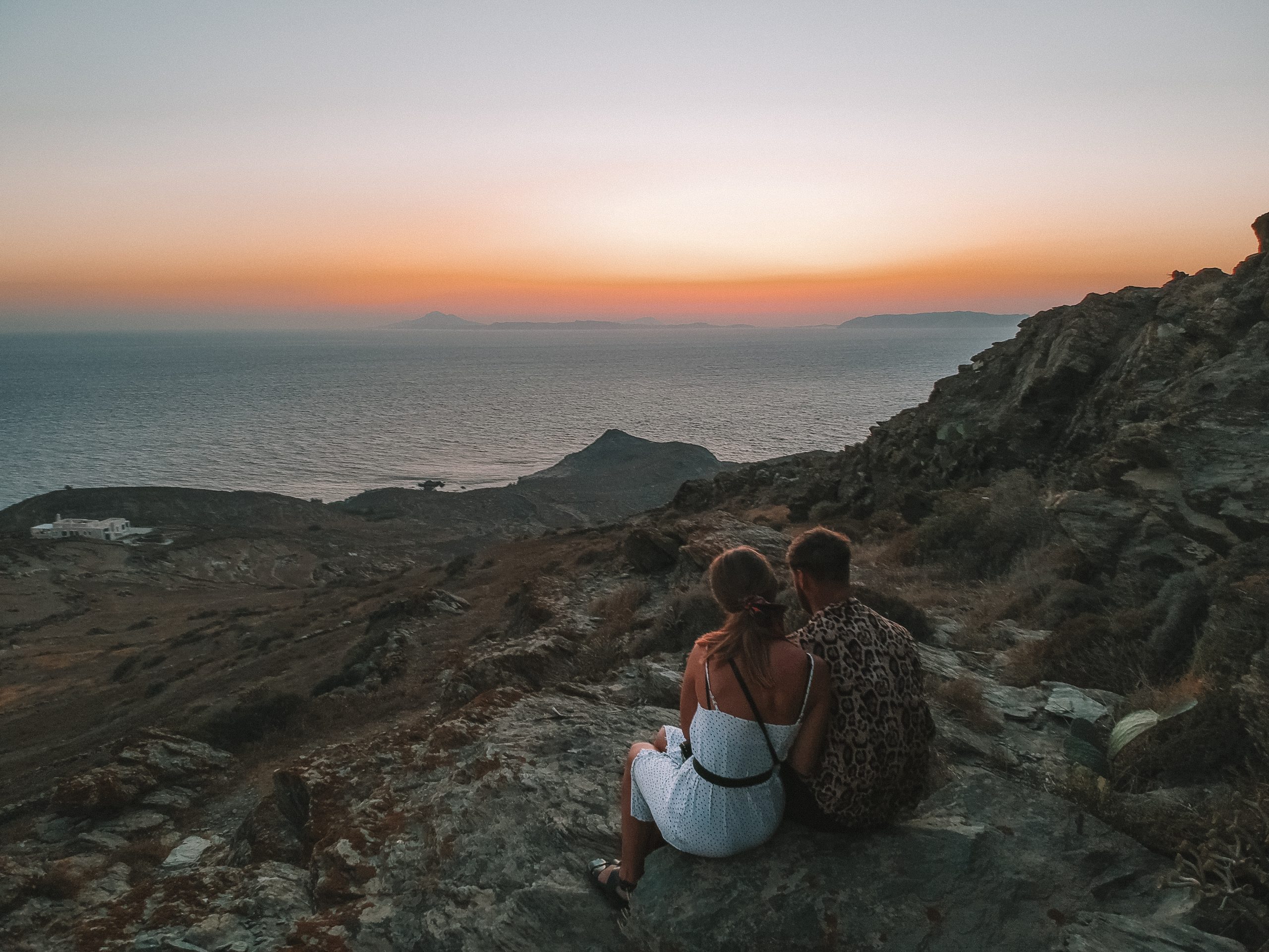 A couple sat on a rock during sunset. What to do in Folegandros