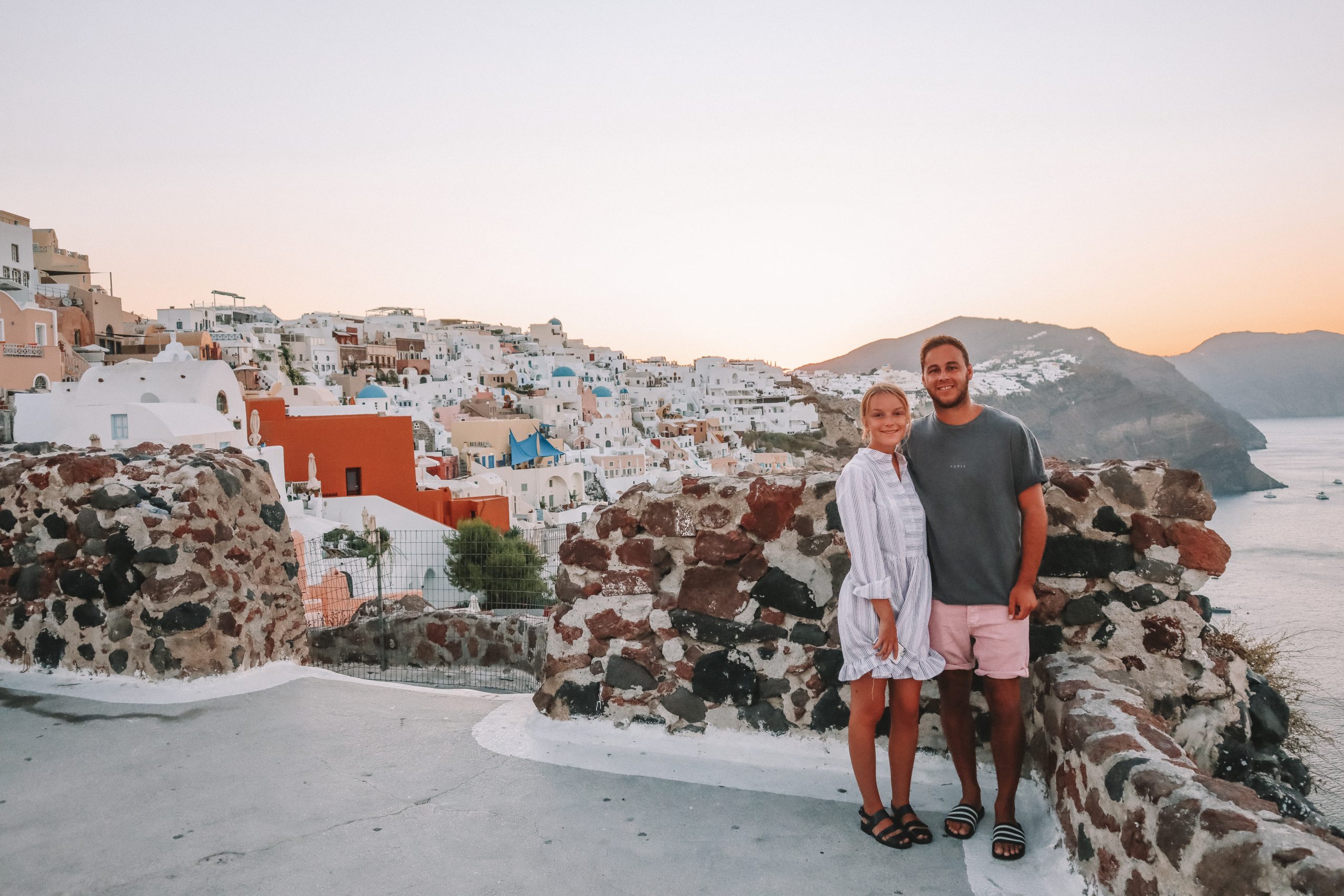 A view from the Kastro in Oia during sunrise with blue domed churches in the background