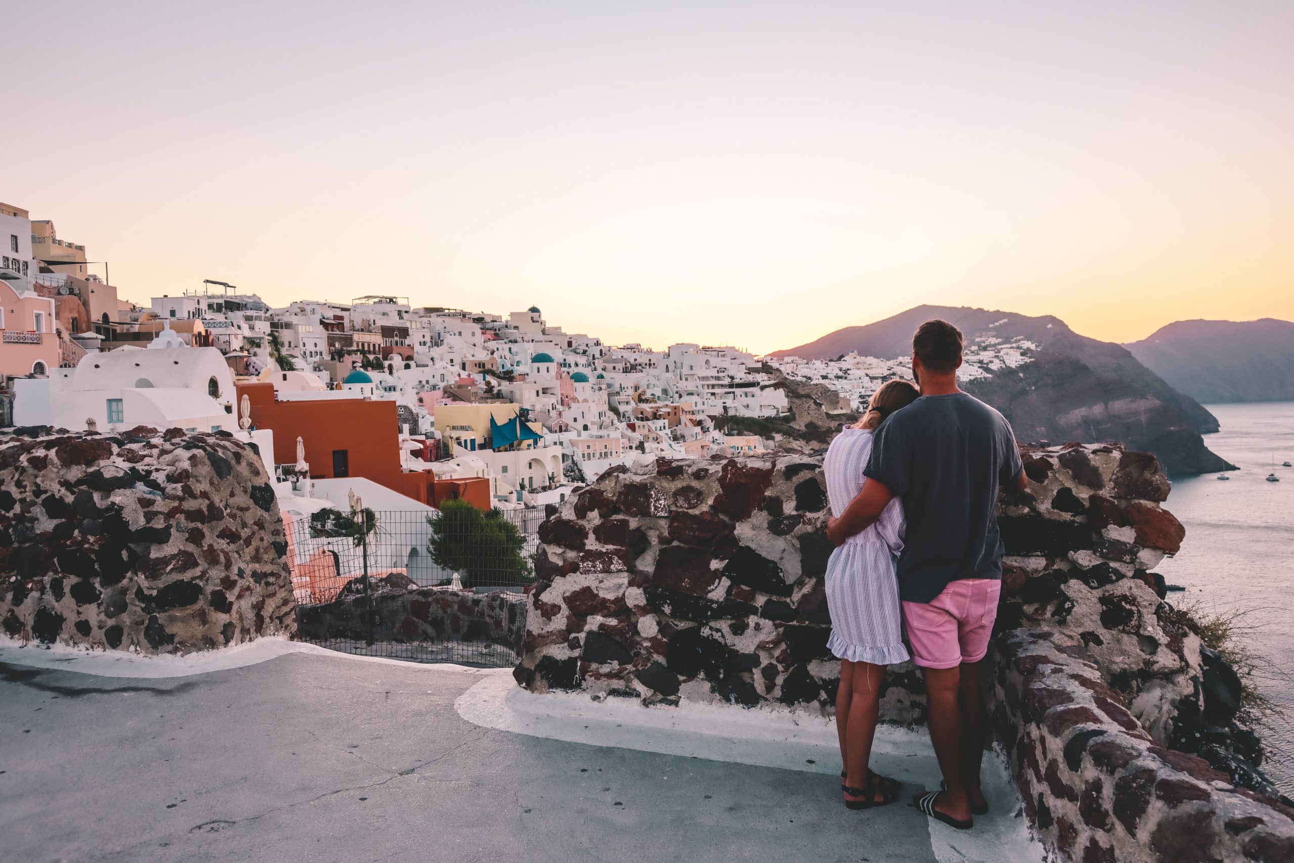 A couple stood watching the sunrise over Oia in Santorini.