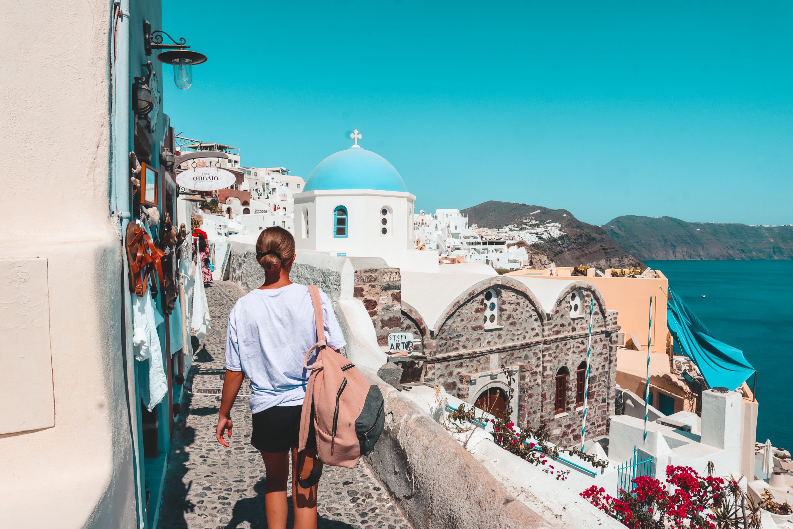 A woman strolling around the streets of Oia. Things to do in Oia