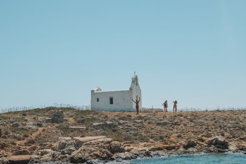 A man infront of a white church on an island. Things to do in Paros